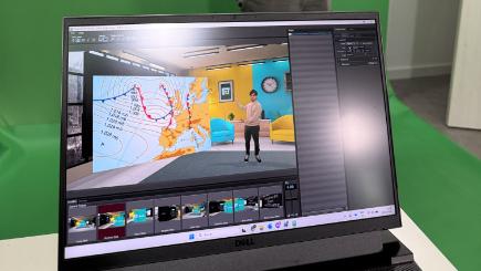 Portátil con Eddie delante de un croma verde, con un presentador en un escenario virtual
